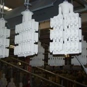 Casting molds hanging on a conveyor line to dry between layers.